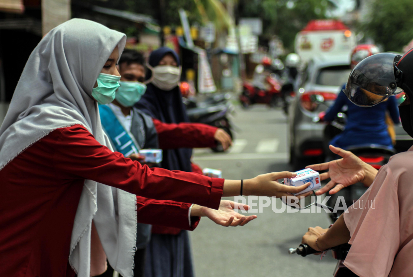 Pelajar membagikan sabun cuci tangan gratis kepada warga pengguna jalan di Lhokseumawe, Aceh.