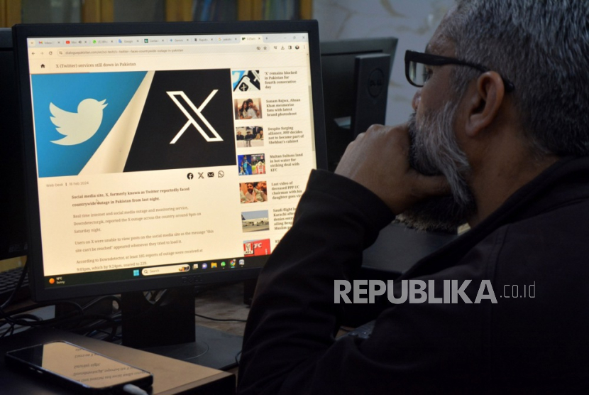 Seorang pria membaca berita tentang blokade platform media sosial X (sebelumnya Twitter) di komputer di Peshawar, Pakistan, 21 Februari 2024.