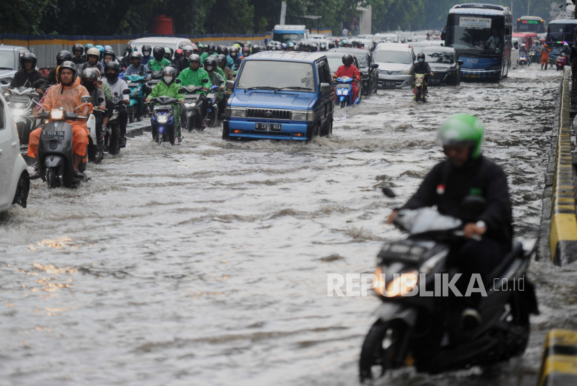 Sejumlah kendaraan melewati genangan air di Jalan Raya Tanjung Barat, Jakarta, Kamis (27/4/2023). Buruknya kualitas drainase membuat jalan tersebut kerap digenangi air saat hujan deras turun sehingga membuat arus lalu lintas tersendat.
