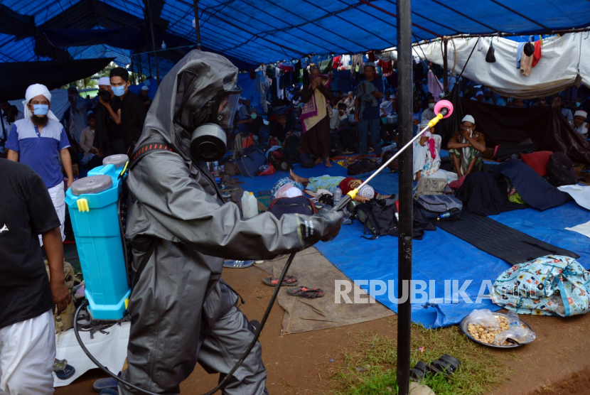 Peserta Ijtima Asia di Asrama Haji Tinggal 250 Orang. Anggota kepolisian Polda Sulsel menyemprotkan cairan di lokasi kegiatan Ijtima Ulama Asia di Desa Pakkatto, Kecamatan Bontomarannu, Kabupaten Gowa, Sulawesi Selatan, Kamis (19/3/2020). 