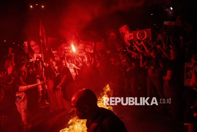 Demonstran membakar api saat melakukan protes di Tel Aviv, Israel, Ahad, 26 Mei 2024.