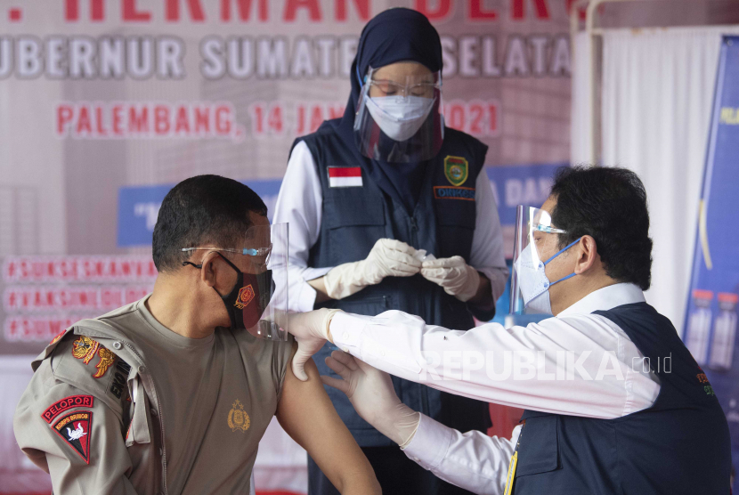 Kapolda Sumatera Selatan Irjen Pol Eko Indra Heri (kiri) disuntik vaksin COVID-19 produksi Sinovac saat pelaksanaan vaksinasi perdana di Puskesmas Gandus, Palembang, Sumatera Selatan, Kamis (14/1/2021).  Penyuntikkan perdana tahap pertama vaksin tersebut selanjutnya dilakukan pada 51.708 orang tenaga kesehatan dan SDM Kesehatan yang ada di Provinsi Sumatera Selatan. 
