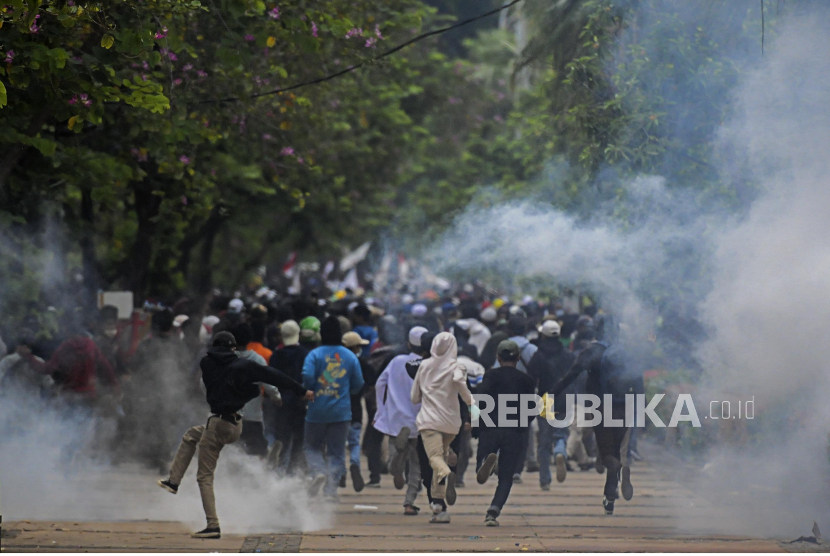 Sejumlah massa berlarian setelah ditembak gas air mata oleh anggota kepolisian dalam aksi demiontrasi menolak disahkan UU Omnibus Law, Rabu (13/10). 