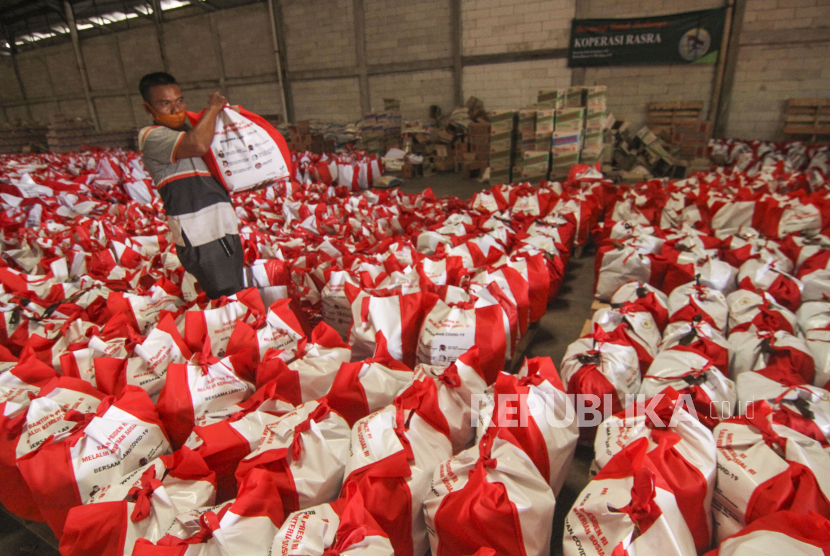 Pekerja menata bantuan paket sembako dan beras dari Presiden Jokowi 
