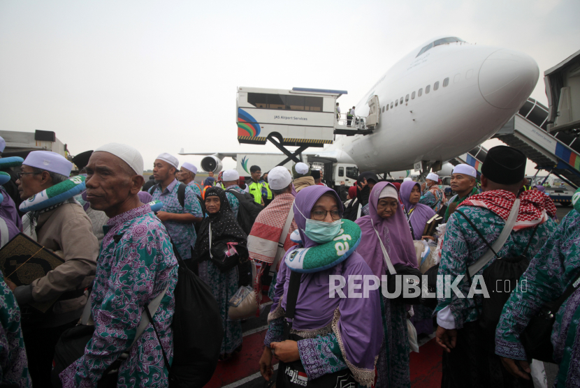 Jamaah haji yang tergabung dalam kelompok terbang (kloter) pertama tiba di Bandara Internasional Juanda Surabaya di Sidoarjo, Jawa Timur, Selasa (4/7/2023). Sebanyak 450 jamaah haji kloter pertama asal Bangkalan, Madura kembali ke tanah air setelah menunaikan ibadah haji.  