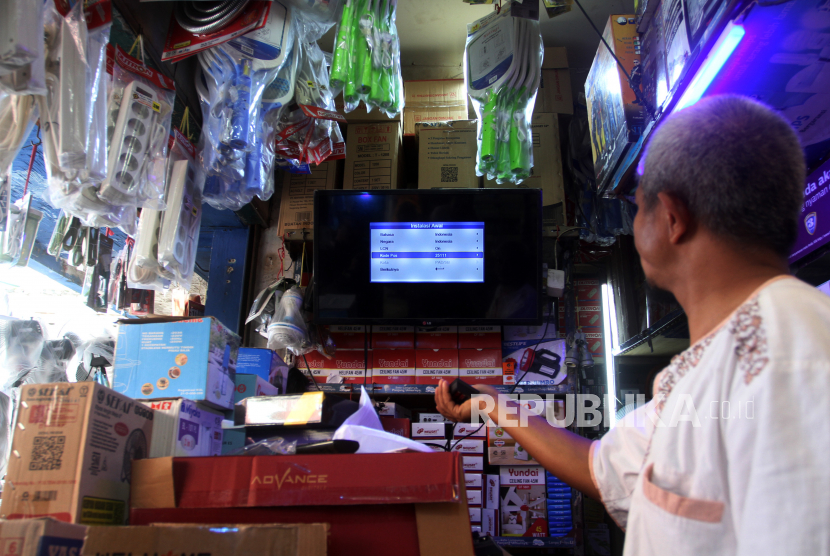 Pedagang menjelaskan pemakaian perangkat set top box TV Digital di Pasar Raya Padang, Sumatera Barat.