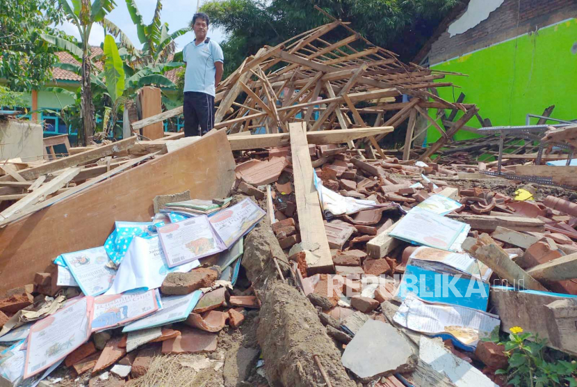 Seorang guru menunjukkan bangunan perpustakaan yang ambruk di SDN 3 Sukajadi, Kecamatan Cisayong, Kabupaten Tasikmalaya, Jawa Barat, Selasa (9/5/2023).