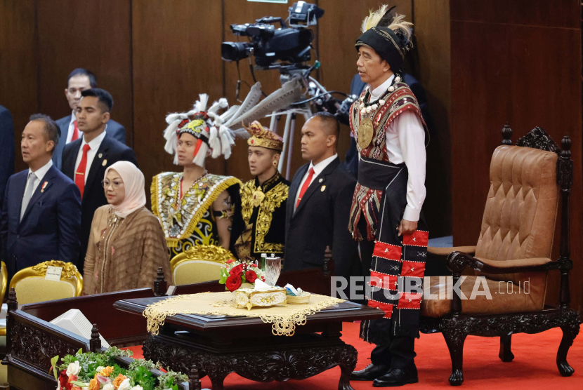 Presiden Joko Widodo (kanan) mengenakan baju adat Tanimbar Maluku mendengarkan lagu Indonesia Raya sebelum menyampaikan pidato kenegaraan di Gedung MPR/DPR, Jakarta, Rabu (16/8/2023).