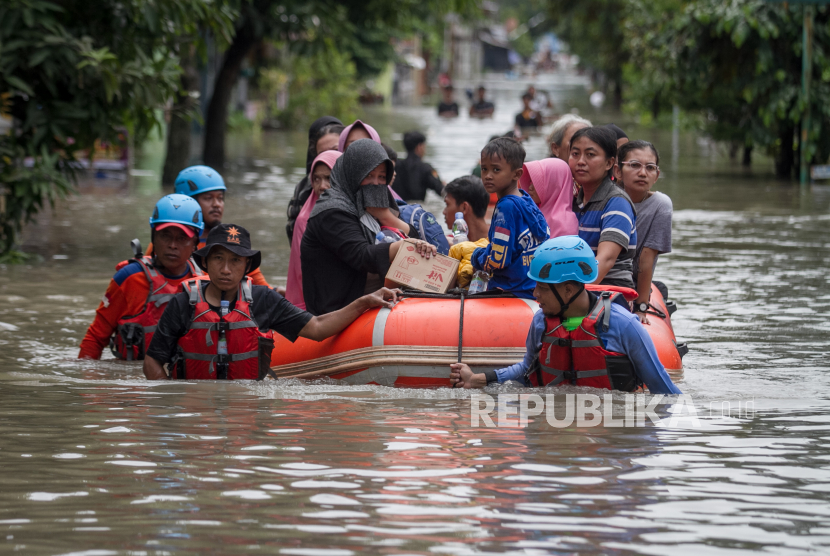 Petugas SAR dan Relawan mengevakuasi warga dengan menggunakan perahu saat banjir di Kampung Joyotakan, Solo, Jawa Tengah, Jumat (17/2/2023). Kepala BPBD Kota Solo menetapkan status banjir di wilayah itu siaga merah.