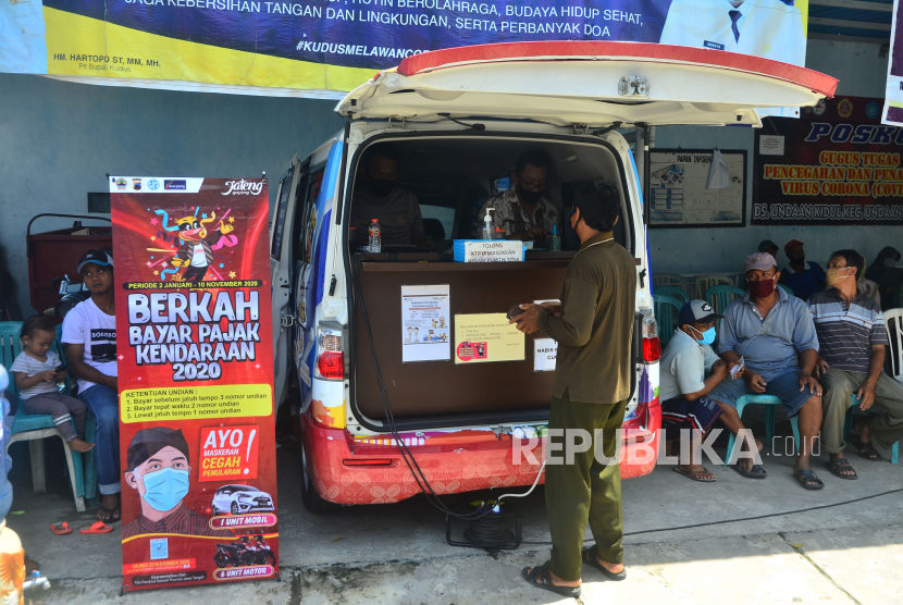 Warga membayar pajak kendaraan bermotor di Mobil Samsat Keliling di Desa Undaan Kidul, Kudus, Jawa Tengah, Rabu (11/11/2020). Mobil samsat keliling tersebut dioperasikan guna menjangkau dan mempermudah masyarakat di daerah pelosok dalam mengurus pembayaran pajak kendaraan bermotor terlebih saat pandemi COVID-19.