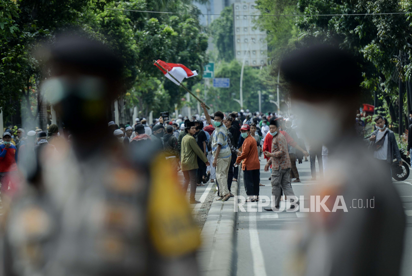 Massa aksi  unjuk rasa 1812 Front Pembela Islam (FPI) membubarkan diri usai dibubarkan paksa Aparat Kepolisian saat hendak menggelar aksi di sekitar Patung Kuda Arjuna Wiwaha, Jakarta Pusat, Jumat (18/12). Polisi memukul mundur massa yang menolak dibubarkan guna menghindari kerumunan. Sebanyak 5.000 personel gabungan dari unsur TNI-Polri dan Pemprov DKI Jakarta disiapkan untuk mengawal dan mengamankan unjuk rasa 1812 di kawasan Istana Negara. Republika/Thoudy Badai