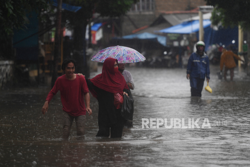 Warga berjalan melintasi banjir yang merendam kawasan RW 5, Duren Tiga, Pancoran, Jakarta, Kamis (18/2/2021). Sejumlah kawasan di Jakarta terendam banjir akibat curah hujan yang tinggi.