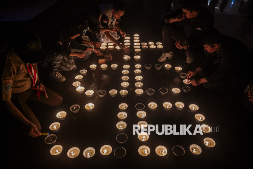 Sejumlah anggota komunitas menyalakan lilin saat pemadaman lampu selama satu jam pada peringatan Earth Hour di Hotel Best Western Plus Coco, Palu, Sulawesi Tengah, Sabtu (22/3/2025) malam. Peringatan Earth Hour yang dinisiasi Himpunan Pramuwisata Indonesia (HPI) Kota Palu itu dilakukan serentak di 22 negara, merupakan ajakan kepada individu, komunitas, pebisnis, dan pemerintah di seluruh dunia untuk berkontribusi dalam mitigasi perubahan iklim secara simbolis melalu aksi mematikan lampu dan alat elektronik selama satu jam mulai pukul 20.30 - 21.30 setiap hari Sabtu di pekan terakhir bulan Maret setiap tahunnya. 