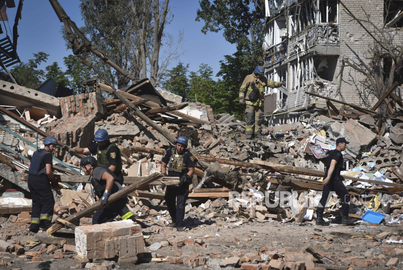 Layanan darurat Ukraina bekerja di samping bangunan yang hancur akibat serangan Rusia pada Minggu di kota Orikhiv, wilayah Zaporizhzhia, Ukraina, Senin, 10 Juli 2023.