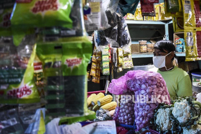 Pedagang mengenakan masker merapikan dagangannya di Pasar Tradisional Cihapit, Jalan Cihapit, Kota Bandung, Ahad (5/4). Sebagai upaya meminimalisir penyebaran virus Corona (Covid-19) pihak pengurus Pasar Cihapit dibantu berbagai perusahaan dan organisasi menyediakan bilik disinfektan, tempat cuci tangan serta mengimbau kepada seluruh pedagang dan pembeli mengenakan masker saat beraktivitas