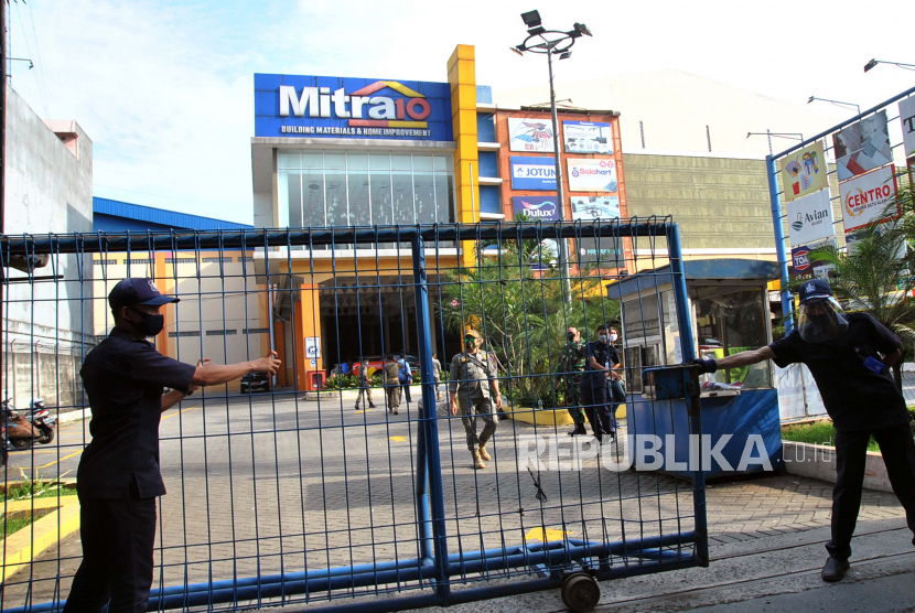 Petugas keamanan menutup pintu gerbang masuk saat penutupan supermarket Mitra10, Kota Bogor, Jawa Barat, Rabu (17/6/2020). Supermarket bahan bangunan dan perlengkapan rumah tersebut ditutup sementara oleh Pemerintah Kota Bogor karena tiga karyawannya positif terinfeksi virus Corona (COVID-19) dari hasil tes swab