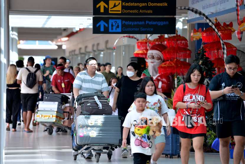 Calon penumpang pesawat membawa barang bawaan di Terminal Domestik Bandara Internasional I Gusti Ngurah Rai, Badung, Bali.