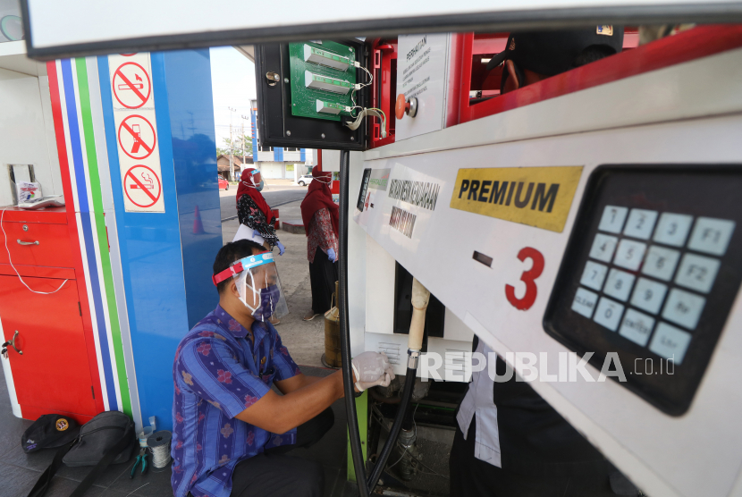 Petugas Dinas Perindustrian dan Perdagangan memasang segel pengaman saat melakukan tera ulang takaran bahan bakar minyak di salah satu stasiun pengisian bahan bakar umum (SPBU) yang curang di Kota Kediri, Jawa Timur, Selasa (14/7/2020).