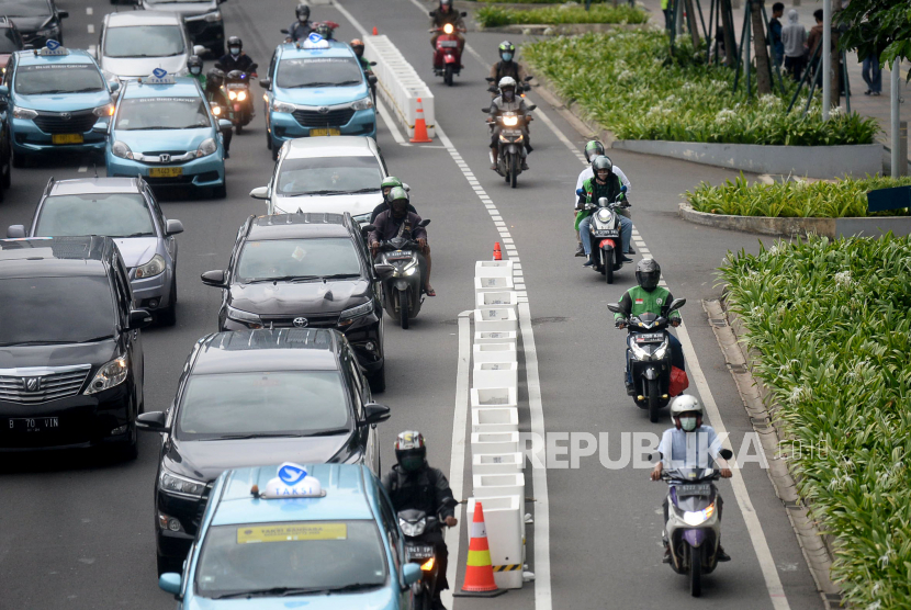 Pengedara sepeda motor melintas di jalur sepeda permanen di Sudirman, Jakarta.