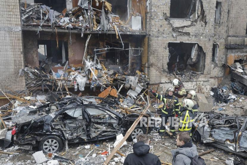 Tim penyelamat bekerja di lokasi bangunan yang rusak setelah serangan rudal di Kyiv (Kiev), Ukraina, (2/1/2024), di tengah invasi Rusia.