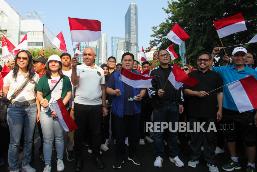 Ketum PSSI Erick Thohir (tengah) dan Wali Kota Surabaya Eri Cahyadi (ketiga kanan) mengibarkan bendera saat Trophy Experience FIFA U-17 World Cup di Surabaya, Jawa Timur,  Ahad (29/10/2023). 