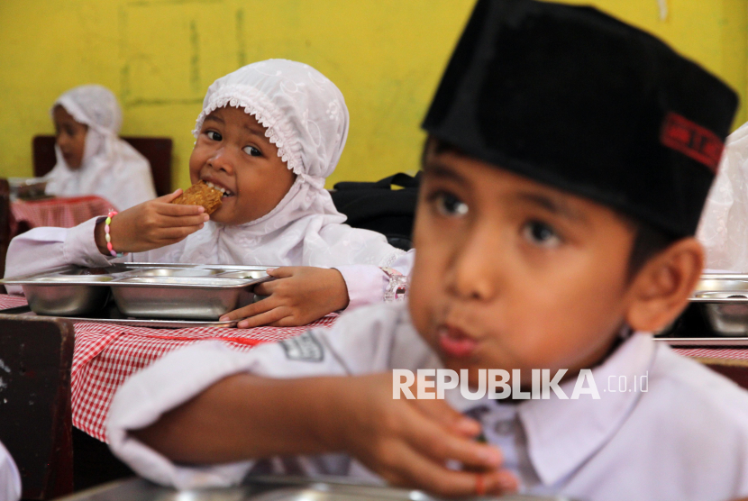 Siswa menyantap makan bergizi gratis di Sekolah Madrasah Ibtidaiyah Negeri Medan, Sumatera Utara, Rabu (14/1/2026).