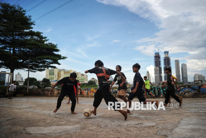 Anak-anak bermain bola di Ruang Terbuka dekat bantaran kali, Petamburan, Jakarta, Jumat (27/1/2025). Minimnya lahan bermain di Jakarta menjadi masalah yang sering terjadi sehingga anak-anak terpaksa bermain di tempat-tempat yang tidak layak. Pemerintah Provinsi (Pemprov) DKI Jakarta akan terus memperluas Ruang Terbuka Hijau (RTH) guna meningkatkan kualitas lingkungan dan memberikan ruang interaksi bagi masyarakat. Setelah sukses membangun 14 RTH baru dan menata 24 lokasi pada tahun 2024, tahun ini Pemprov DKI Jakarta menargetkan pembangunan 21 RTH baru dan penataan 73 lokasi yang tersebar di seluruh Jakarta.