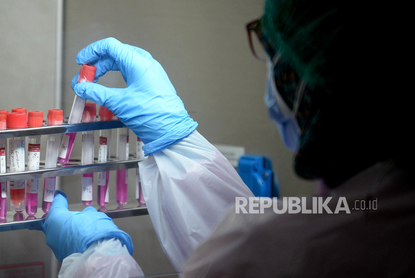 Petugas mengecek spesimen tes usap PCR di lab. Ilustrasi