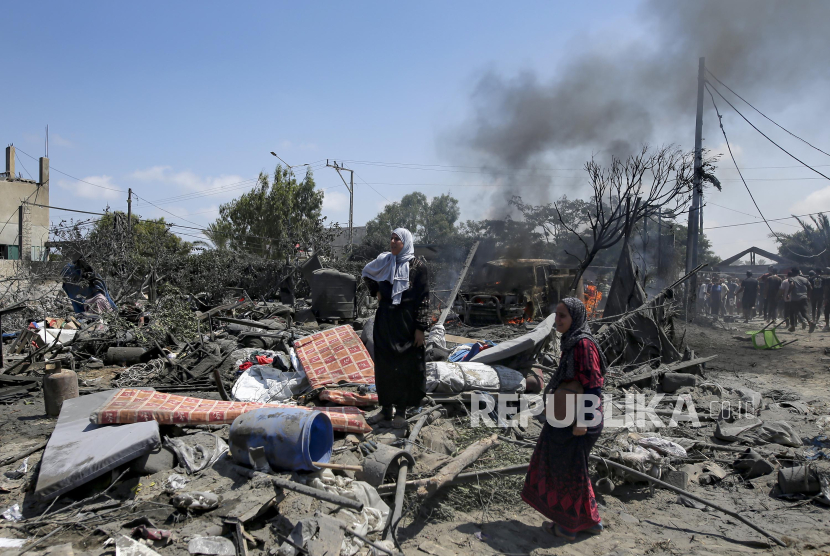 Warga Palestina memeriksa kerusakan di lokasi yang terkena pemboman di Khan Younis, Jalur Gaza selatan, Sabtu (13/7/2024).