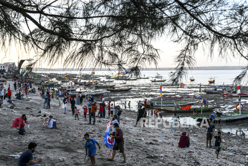 Warga bermain di pesisir pantai batu-batu Kenjeran, Surabaya, Jawa Timur, Ahad  (20/9/2020). Pantai tersebut menjadi objek wisata alternatif ketika ditutupnya Taman Hiburan Pantai (THP) Kenjeran untuk sementara waktu karena pandemi COVID-19. 