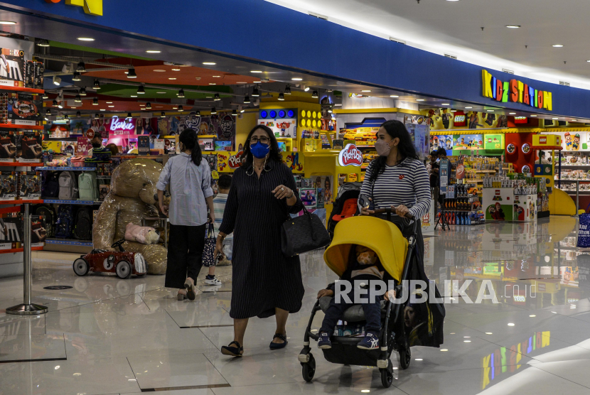 Warga bersama anaknya melewati salah satu gerai toko di Senayan City, Jakarta, Rabu (22/9). Badan Pusat Statistik mencatat, pergerakan masyarakat di tempat belanja kebutuhan sehari-hari sudah dalam kondisi normal. 