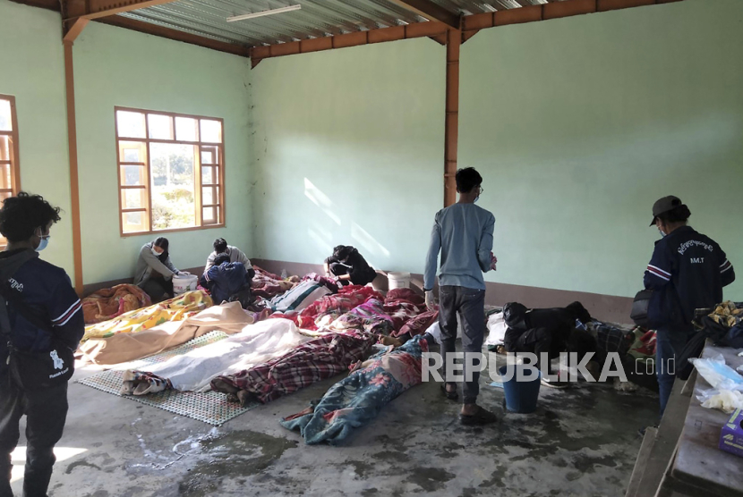   Orang-orang membersihkan korban serangan udara yang diselimuti selimut di sebuah bangunan di desa Kanan, kota Khampat di wilayah Sagaing pada Ahad, (7/1/2024).