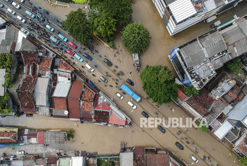 Foto aerial kendaraan melintasi banjir di Jalan Jatinegara Barat, Kampung Pulo, Jakarta, Senin (8/2/2021). Hujan deras mengguyur Ibu Kota sejak Ahad, (7/2) malam. Dinas Lingkungan Hidup (DLH) DKI Jakarta pun telah mengangkut sebanyak 436 meter kubik sampah pascahujan. 
