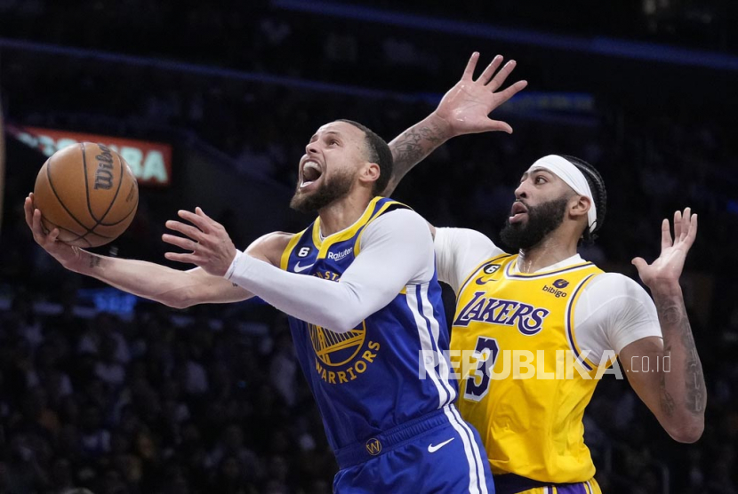 Guard Golden State Warriors Stephen Curry (kiri) melakukan lay up saat melewati pemain Los Angeles, Lakers Anthony Davis pada laga playoff semifinal wilayah barat. LA Lakers menyingkirkan Warriors dengan skor akhir 4-2. (ilustrasi)