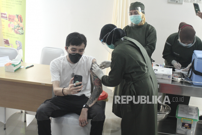 Dokter Tirta Mandira Hudhi (kiri) disuntik vaksin COVID-19 saat pelaksanaan vaksinasi di Puskesmas Ngemplak 2, Sleman, DI Yogyakarta, Kamis (14/1/2021). Dokter Tirta  mendapatkan suntikan pertama di Sleman untuk menandai program vaksinasi massal. 