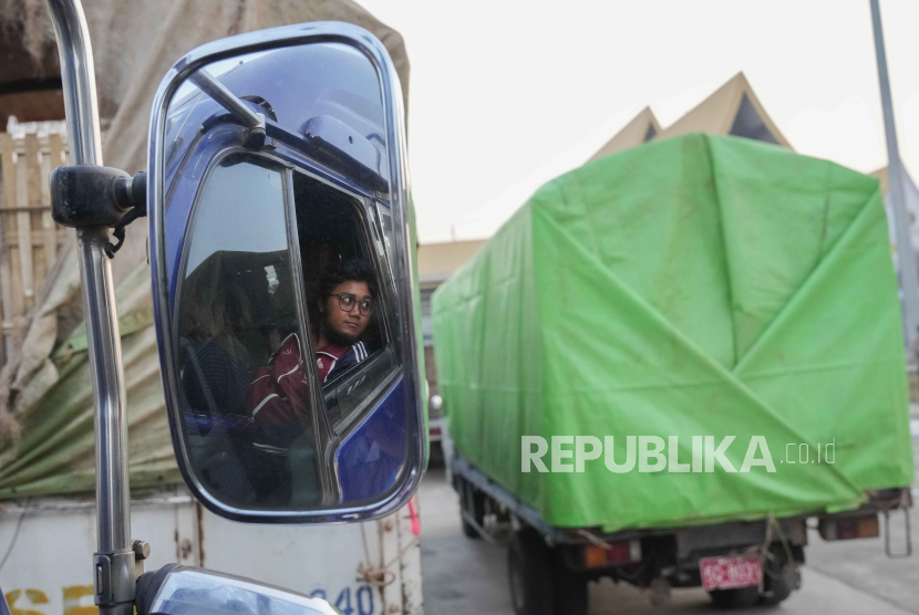  Seorang pengemudi truk Myanmar terpantul di cermin saat truknya yang membawa bantuan berangkat di pos pemeriksaan bea cukai dekat perbatasan dengan Myanmar, di Mae Sot, provinsi Tak Thailand. 