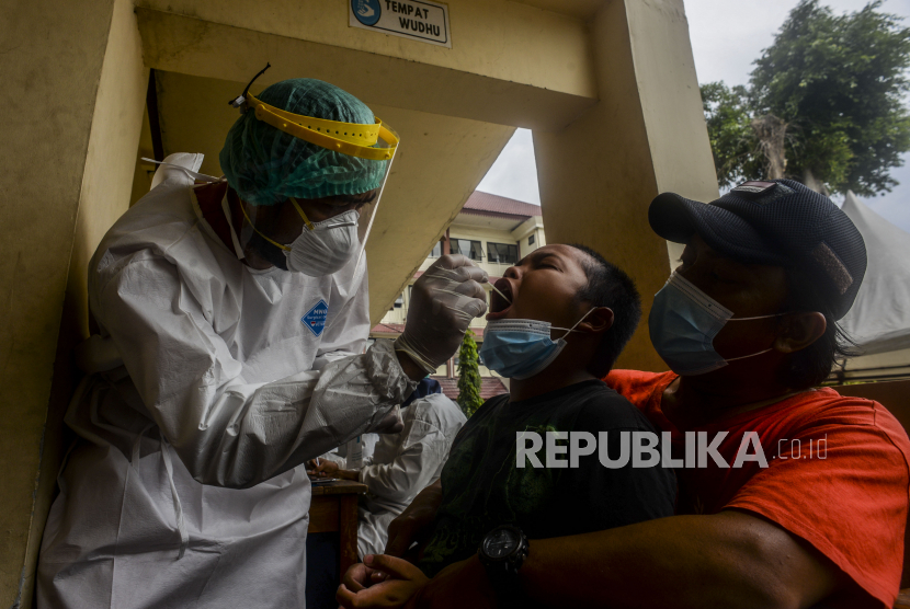 Petugas kesehatan melakukan tes Covid-19 kepada seorang anak di Gelanggang Remaja Kecamatan Matraman, Jakarta, Jumat (11/2/2022). Positif harian Covid-19 di DKI Jakarta hingga pekan ini masih mencapai 10 ribuan kasus.