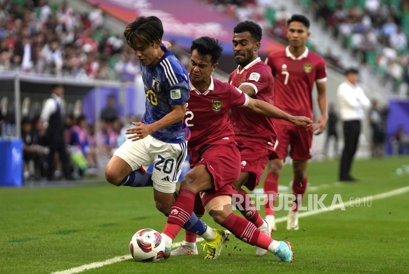 Takefusa Kubo dari Jepang dijaga oleh Pratama Arhan Alif dari Indonesia pada pertandingan sepak bola Grup D Piala Asia antara Jepang dan Indonesia di Al Thumama di Doha, Qatar, Rabu, (24/1/2024).