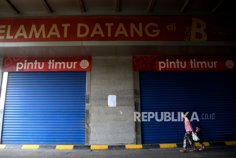 Warga beraktivitas di depan Pasar Tanah Abang Blok A yang tutup di Jakarta, Jumat (27/3). Dalam rangka pencegahan dan menekan angka penularan virus Corona (COVID-19), Perumda Pasar Jaya menutup sementara Pasar Tanah Abang Blok A, B dan F mulai 27 Maret hingga 5 April 2020