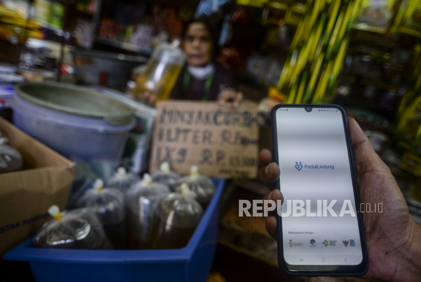Warga memperlihatkan aplikasi PeduliLindungi saat akan membeli minyak goreng curah di pasar (ilustrasi). Pemerintah Kota Mataram, Provinsi Nusa Tenggara Barat, masih menunggu aturan resmi dari pemerintah terkait kebijakan pembelian minyak goreng curah menggunakan PeduliLindungi.