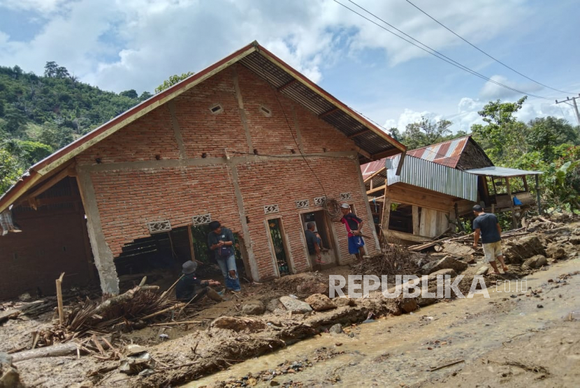 Ilustrasi. Sejumlah warga melintas di pemukiman yang rusak terdampak banjir bandang di Desa  Kalimbua Kecamatan Tapango, Kabupaten Polewali Mandar, Sulawesi Barat. Tim SAR Gabungan Temukan Warga Terseret Banjir di Polewali Mandar
