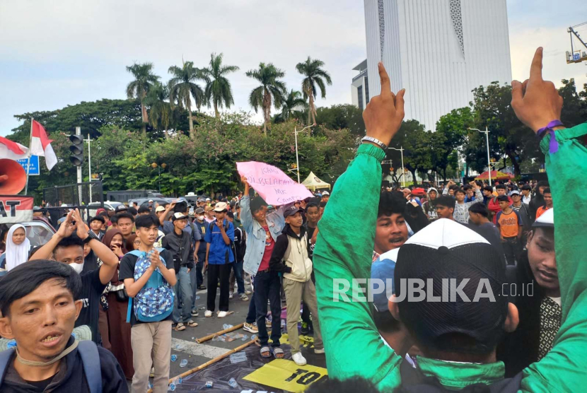 Massa aksi dari salah satu kelompok berjoget bersama saat melakukan aksi di kawasan Patung Kuda, Jalan Medan Merdeka Barat, Kecamatan Gambir, Jakarta Pusat, Jumat (19/4/2024). 
