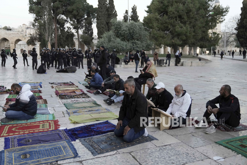 Muslim  Palestina membaca Alquran  ketika polisi Israel dikerahkan di kompleks Masjid Al-Aqsa menyusul penggerebekan di lokasi tersebut selama bulan suci Ramadhan di Kota Tua Yerusalem, Rabu (5/4/2023). Apa Arti Status Quo di Masjid Al Aqsa di Yerusalem?