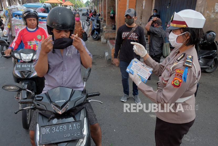 Polisi membagikan masker kepada pengendara sepeda motor dalam giat operasi keselamatan agung 2020 di Denpasar, Bali, Rabu (8/4/2020). Kegiatan yang digelar Polresta Denpasar tersebut untuk memberikan pemahaman pentingnya mengikuti imbauan pemerintah dalam upaya mencegah penyebaran COVID-19 atau Virus Corona