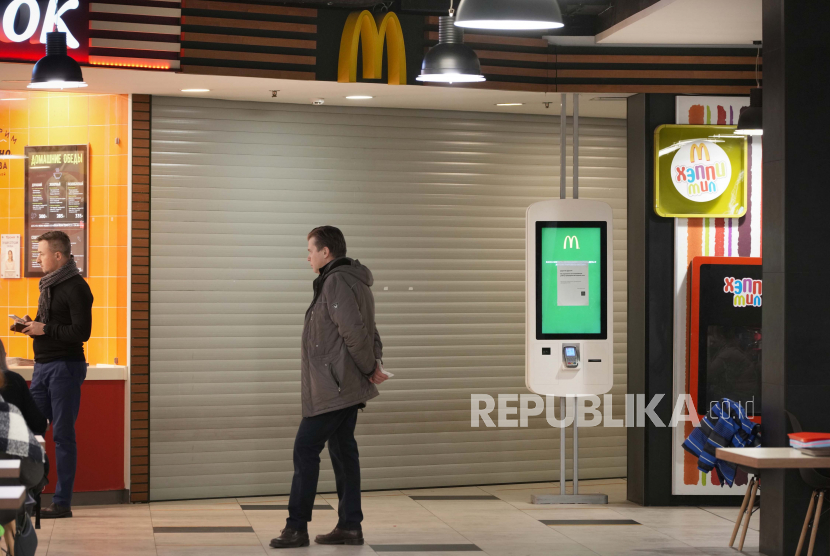 Seorang pria berdiri di sebelah restoran McDonald
