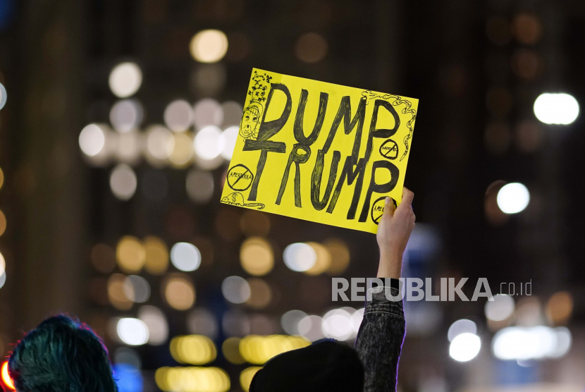  Seorang demonstran memegang tanda mengacu pada Presiden Donald Trump selama pawai untuk mendesak agar semua suara dihitung, Rabu, 4 November 2020, di Philadelphia, setelah pemilihan hari Selasa.