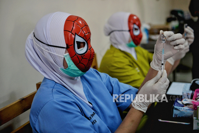 Tenaga kesehatan menggunakan topeng pahlawan super (superhero) saat melayani vaksinasi anak usia 6-11 tahun di RSIA Tambak, Menteng, Jakarta Pusat, Rabu (22/12). Penggunaan topeng superhero tersebut guna menarik minat anak-anak untuk mengikuti vaksinasi Covid-19. Sebanyak 30 anak mengikuti vaksinasi yang menggunakan vaksin Sinovac tersebut. Republika/Thoudy Badai