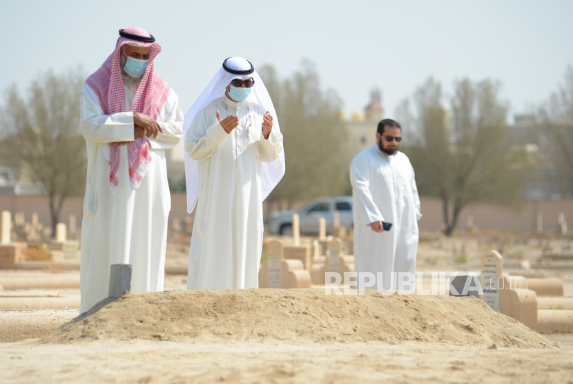 Dunia Turunkan Bendera Setengah Tiang untuk Emir Kuwait. Orang-orang berdoa di dekat Makam almarhum Emir Kuwait Sheikh Sabah Al-Ahmad Al-Jaber Al-Sabah, di pemakaman Sulaibikhat, di Kuwait City, Kuwait, pada 01 Oktober 2020.