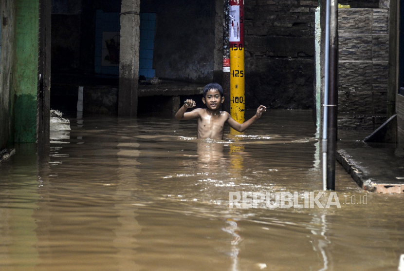 Anak-anak melewati banjir di kawasan Kebon Pala, Kampung Melayu (ilustrasi)
