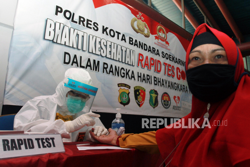 Petugas medis dari Dokkes Polres Metro Bandara Soetta dan Artha Graha Peduli mengambil sampel darah calon penumpang pesawat  saat tes diagnostik cepat (rapid test) COVID-19 di Terminal 2 Bandara Soekarno Hatta, Tangerang, Banten. 
